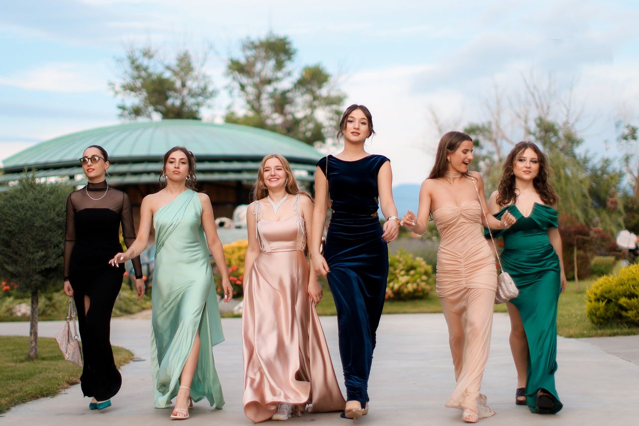 Crafting Captivating Headlines: Your awesome post title goes here A group of six women in elegant evening dresses walking confidently outdoors, showcasing fashion and style.